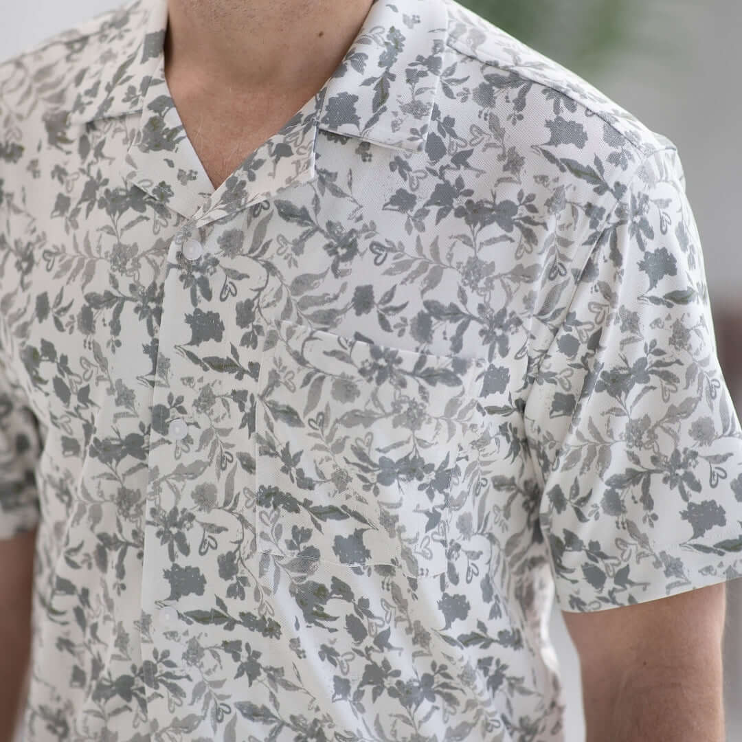 Close-up of a man wearing a grey floral untucked short sleeve adaptive shirt for comfort and mobility.