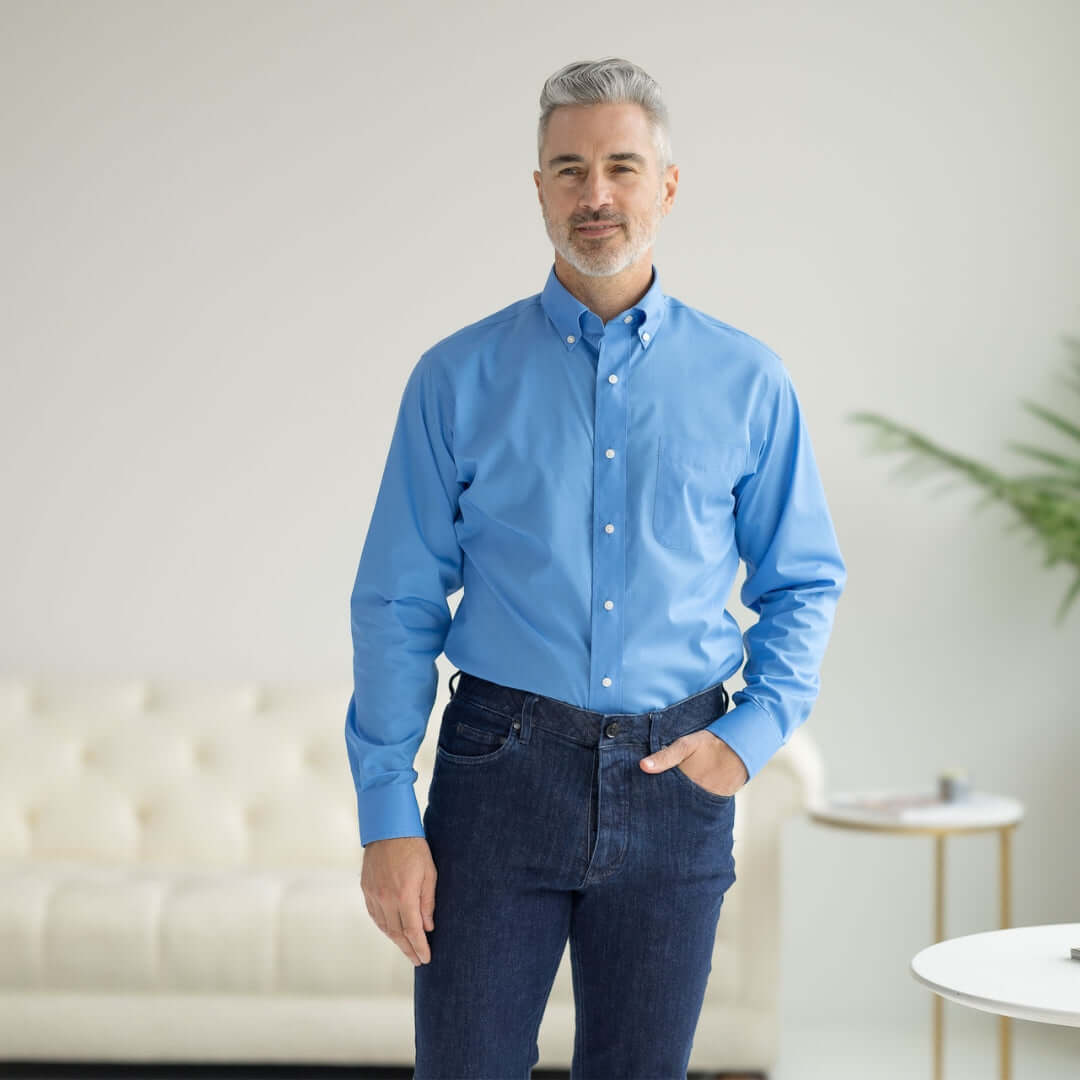 Man wearing a blue long sleeve button-down collar shirt with magnetic closures, styled casually.