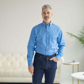 Man wearing a blue long sleeve button-down collar shirt with magnetic closures, styled casually.