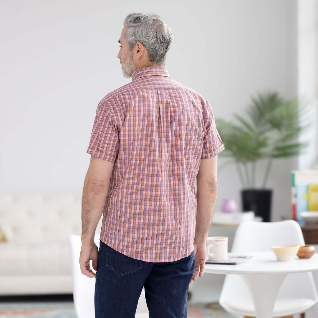 Back view of a man in an orange plaid short sleeve button-down shirt, designed for comfort and ease of wear.