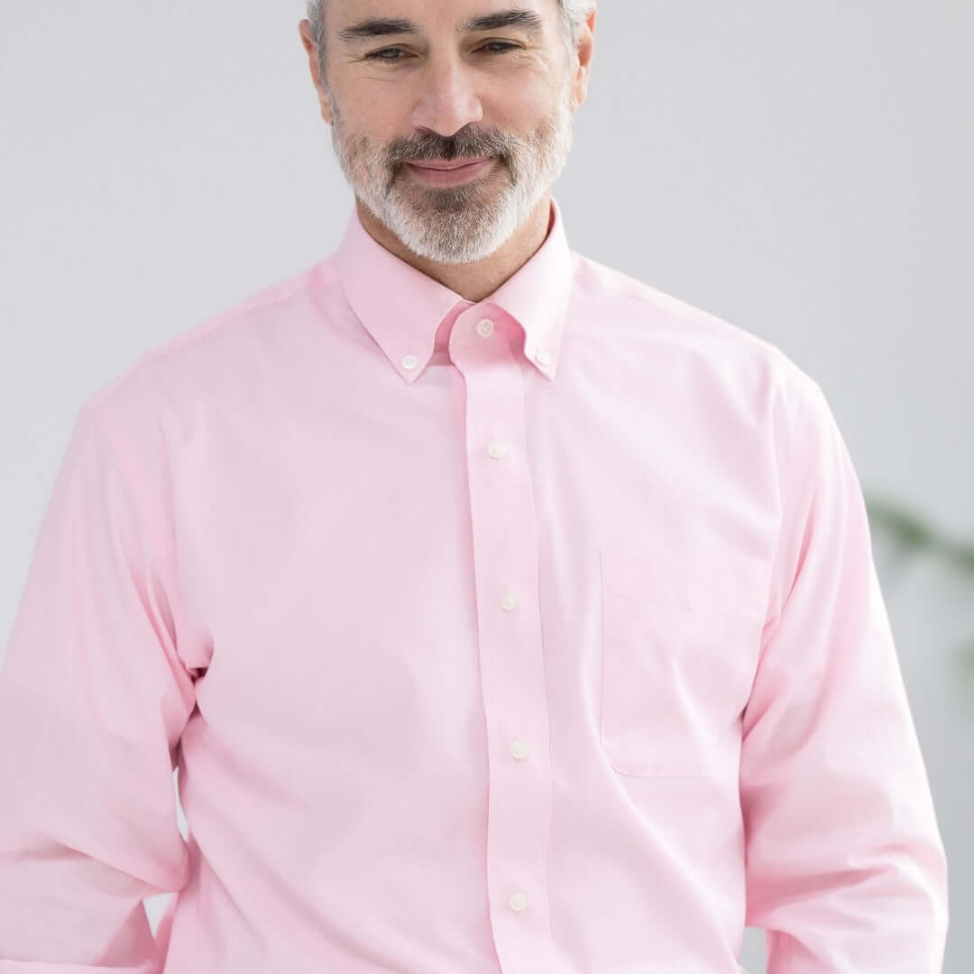 Man wearing a pink long sleeve button-down collar shirt with magnetic closures, showcasing adaptive menswear.